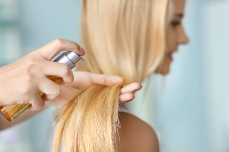 Stylist Spraying Hair Oil Onto Hair