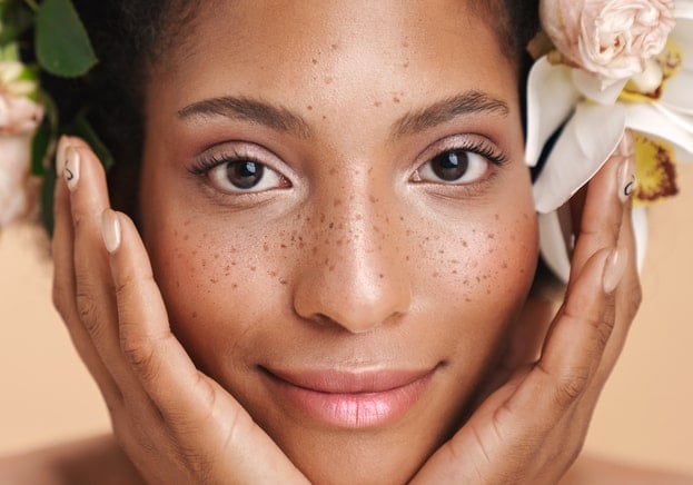 Portrait of half-naked african american woman with flowers in her hair - Beautygab