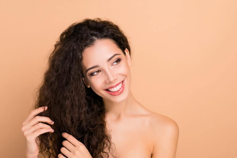 Woman Touching Her Hair And Smiling