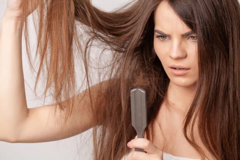 Woman Holding Hair and Looking at Brush