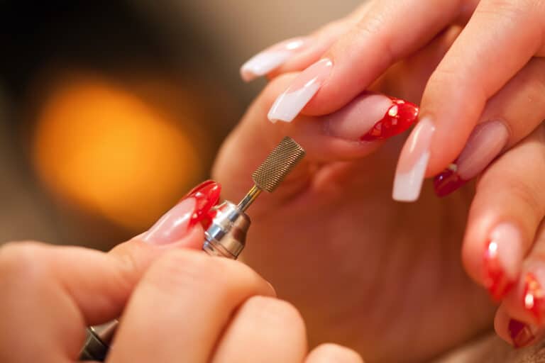 Manicurist Filing Fake Nails