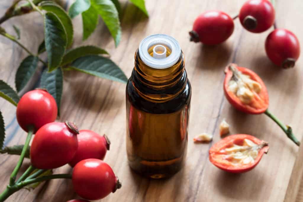 A bottle of rosehip seed oil on a wooden table - Beautygab Jojoba Oil