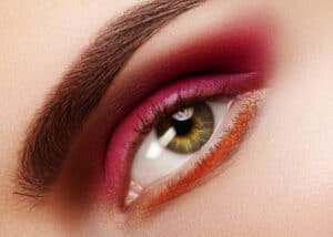 Beauty Close-up Beautiful Female Eye. Celebrate Fashion Make-up with Red Eyeshadows. Christmas or Valentines Day Makeup - Beautygab