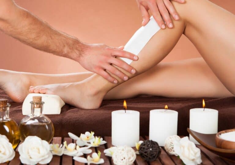 Waxing oil and wax strips laid out for a hair removal session
