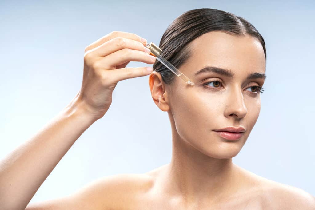 Best Under Eye Oils - Beautygab Facial oil dropper held above the under eye area