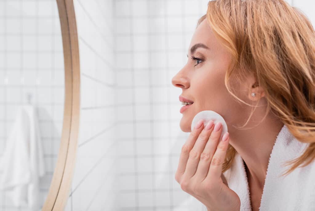 9 Best Hyaluronic Acid Toners - Beautygab Side view of woman applying toner with cotton pad on face