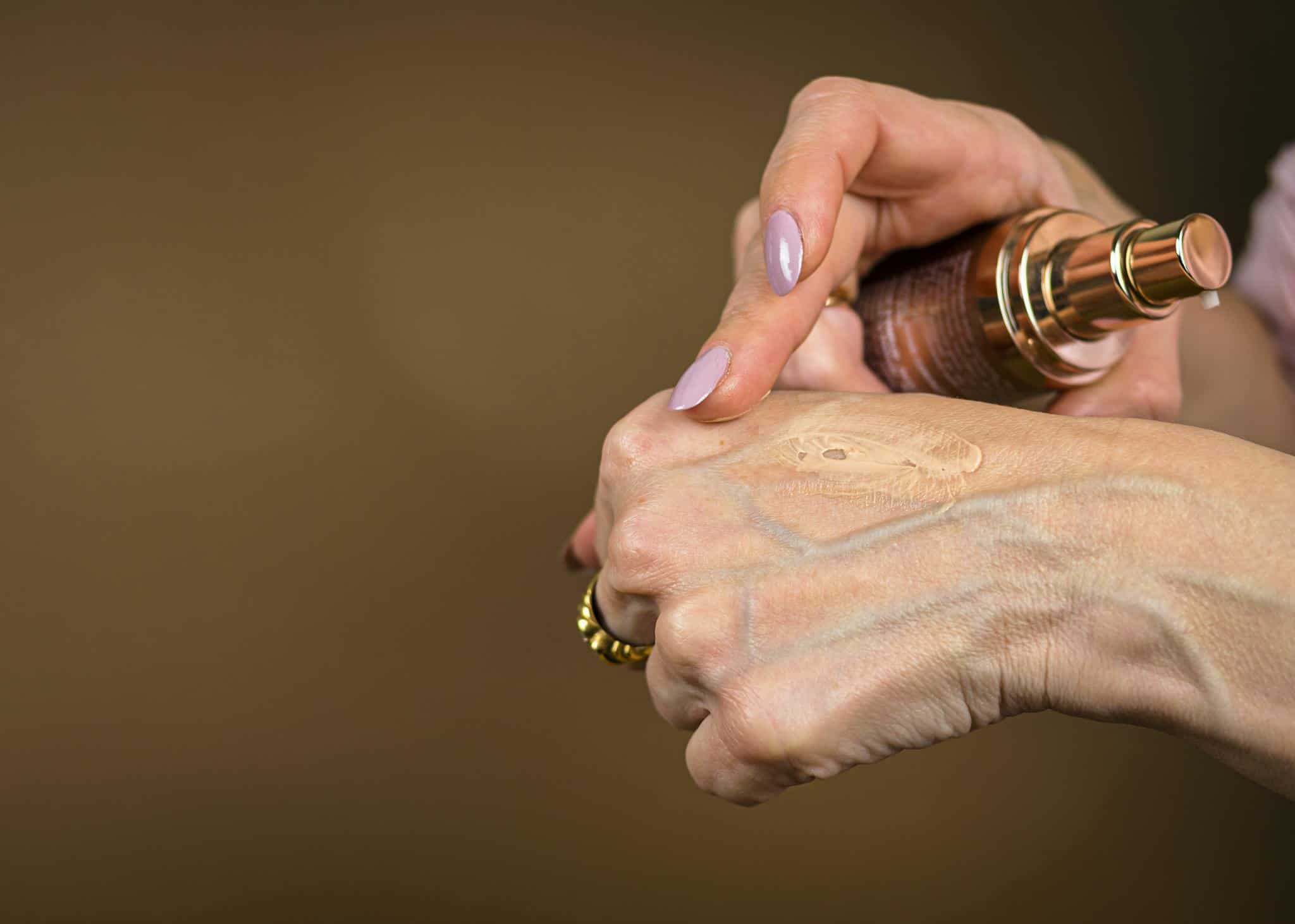 Photo by Ahimsa - OM - Beautygab A detailed shot showing foundation being applied to hand skin care routine.