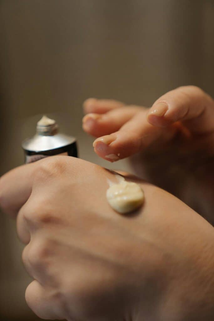 Hands scooping a whipped moisturizer out of a jar